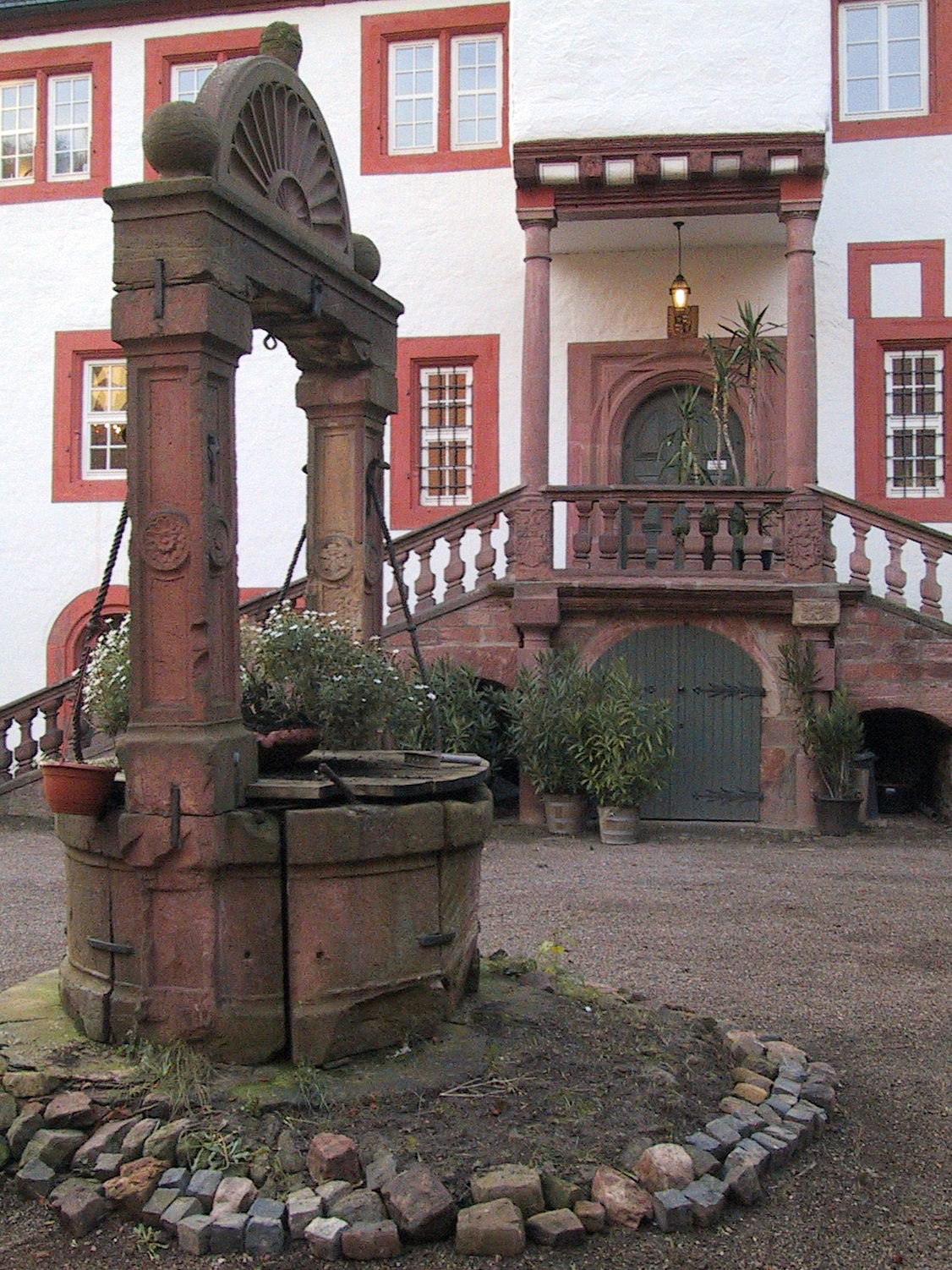 Innenansicht des Schlosshofes mit Treppenaufgang und Schöpfbrunnen