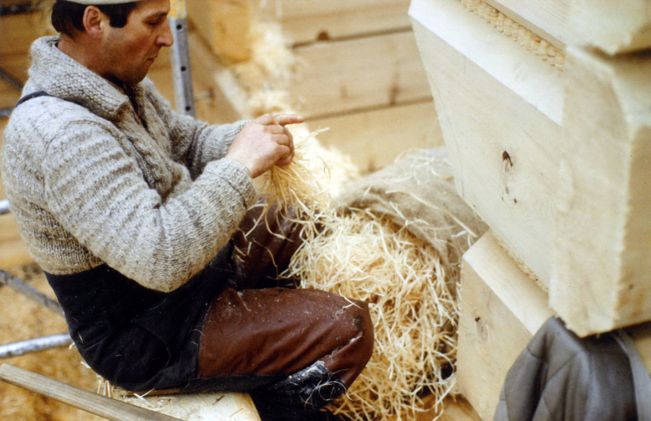 Holzwolle dient zur Isolation zwischen den Balkenfugen