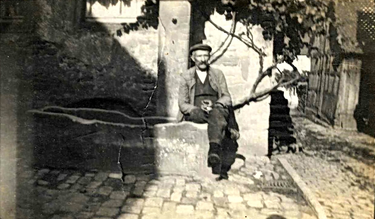 Karl Süß am Brunnen vor dem Haus Kleine Gasse 1, (früher Hauptstraße 20) um 1920